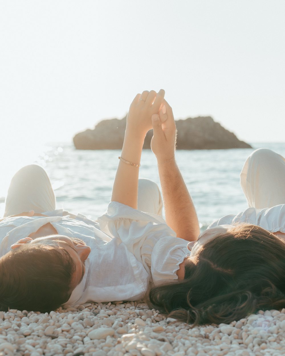 Couple lying on a pebble beach in Lefkada