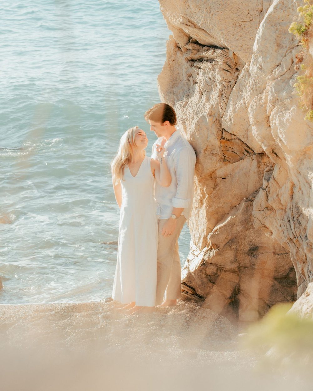 Couple by a limestone cliff above the sea in Lefkada
